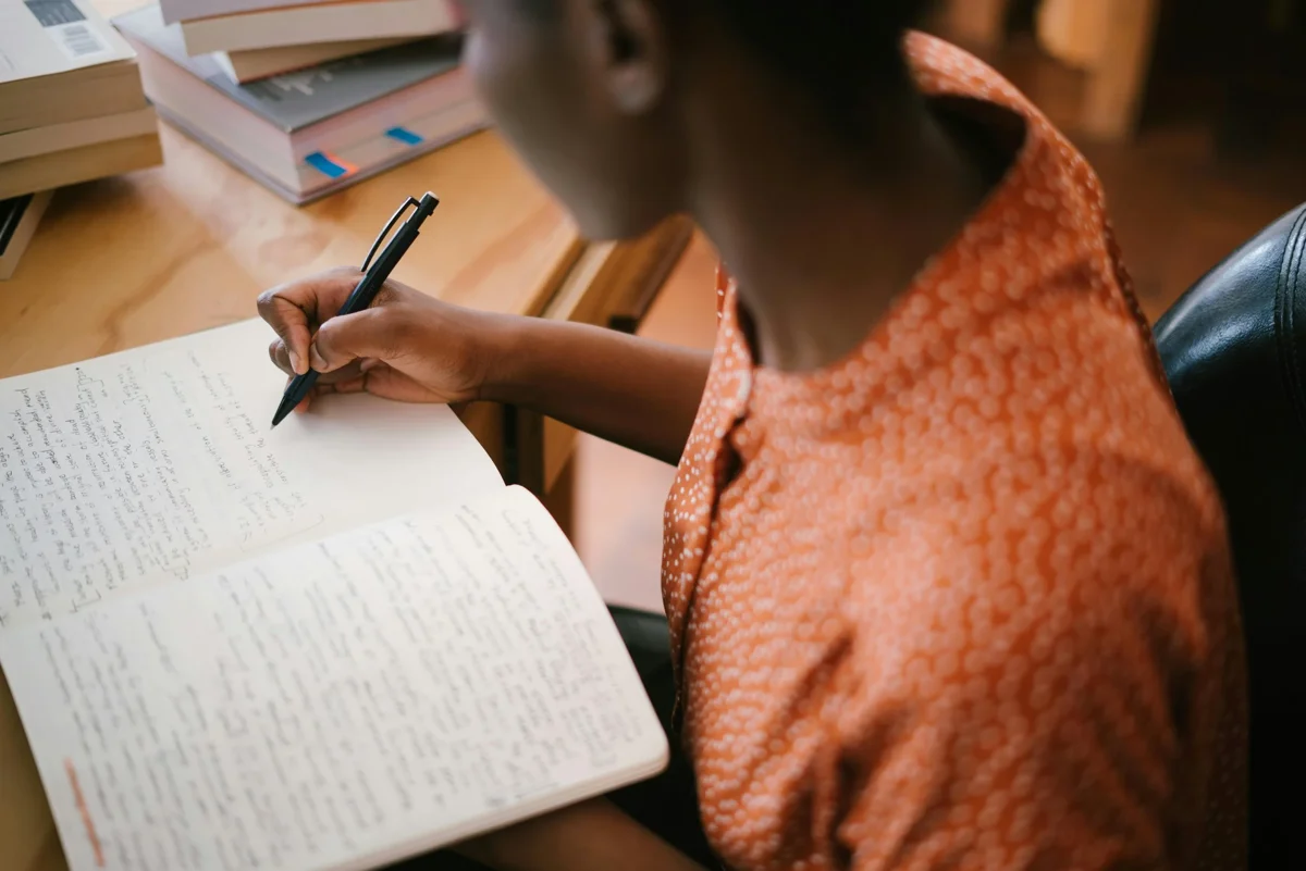 Pessoa escrevendo à mão em um caderno
